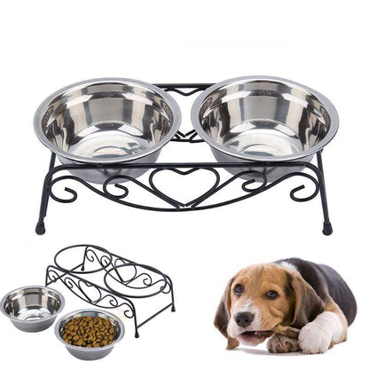 Double stainless steel pet bowl set with decorative black metal stand and a dog lying beside it