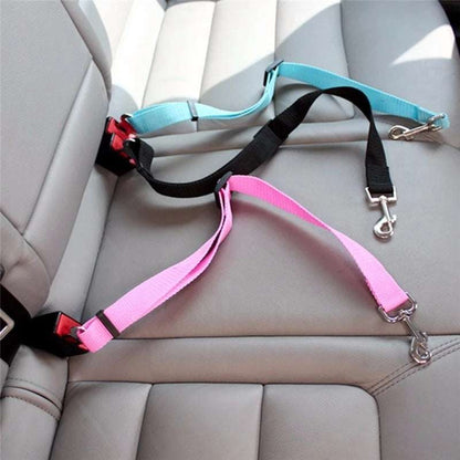 Golden retriever wearing red adjustable pet car seat belt harness secured to car seat buckle