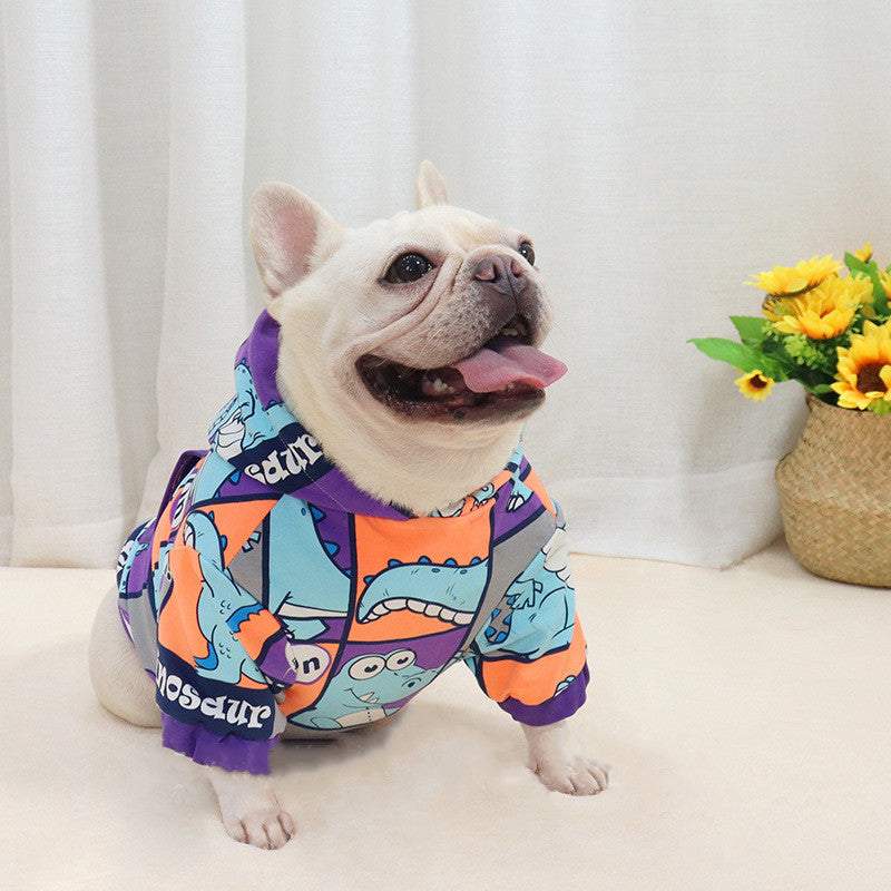 French bulldog wearing colorful little dinosaur hooded fleece-lined Jarre Aero Bull Winter sweater indoors near flowers
