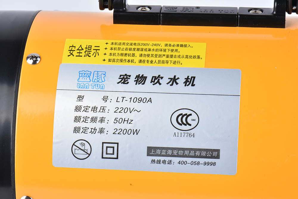 Pink metal dog hair dryer with black hose and four nozzle attachments on white background